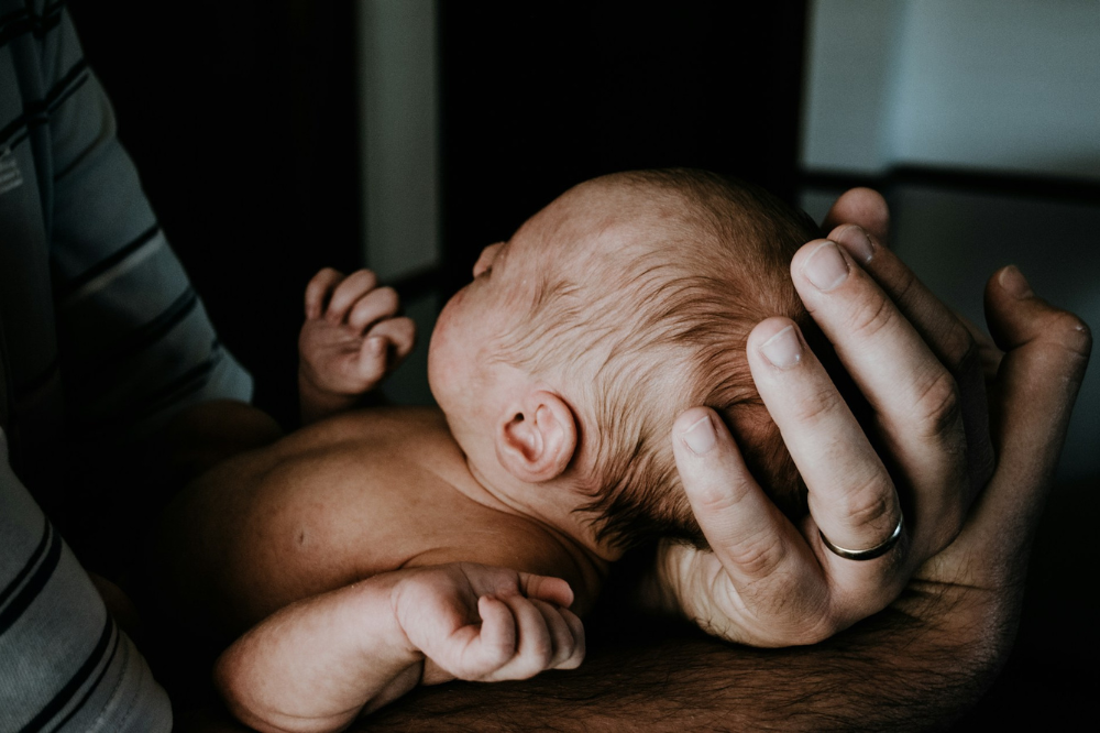 Vater hält Baby in seinen Händen